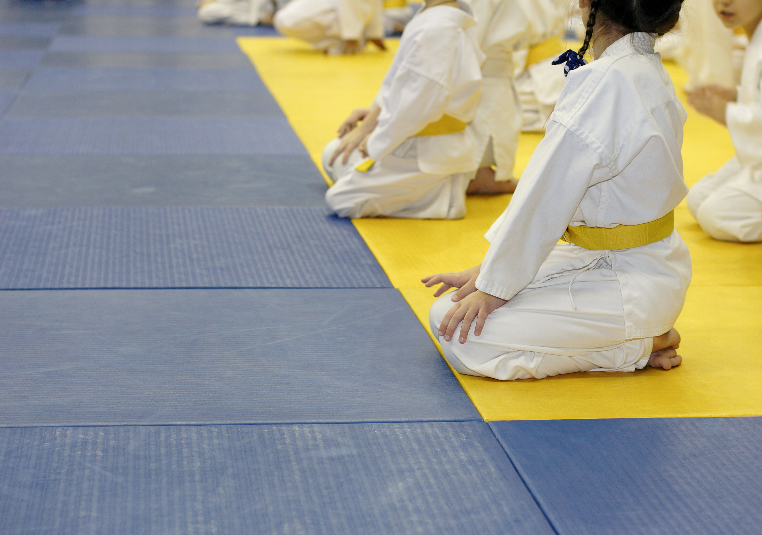 Girl in kimono for martial arts sitting on tatami